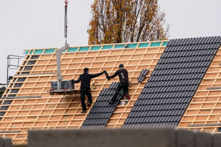 Ouvriers installant des tuiles sur un nouveau bâtiment